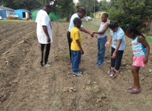 Black mentors teach black elementary school students learn how to plant seeds