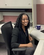 Photo of young Black woman sitting at desk