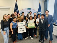 A group of interns standing together with flags in the background