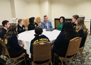 A group of high school students sits at a round table with USDA staff