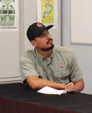 Young Native American Man seated wearing cap