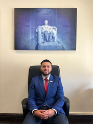 A young man sits below a picture of Abraham Lincoln statue