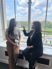 Two Hispanic women sitting by a window chatting