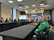 Group of men and women sitting at a U-shaped conference table