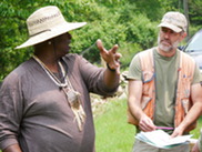 Two men in hats talking in a field