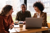 Group of college students gathered around a laptop
