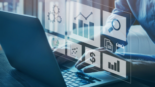A laptop with the screen contents projected from it showing a data dashboard
