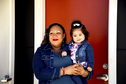 Photo of Cora Ortiz with her youngest daughter, Estefania, in front of their new apartment in The Dalles.