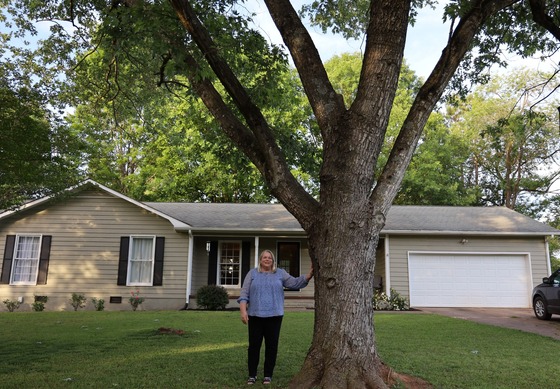 A homeowner in Georgia stands in her front yard