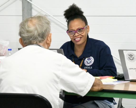 A FEMA Individual Assistance Specialist assists a resident at a disaster recovery center.