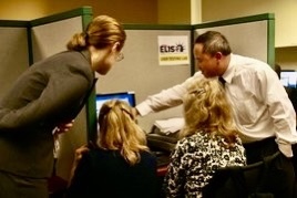 Team members gathered around a computer sharing insights.