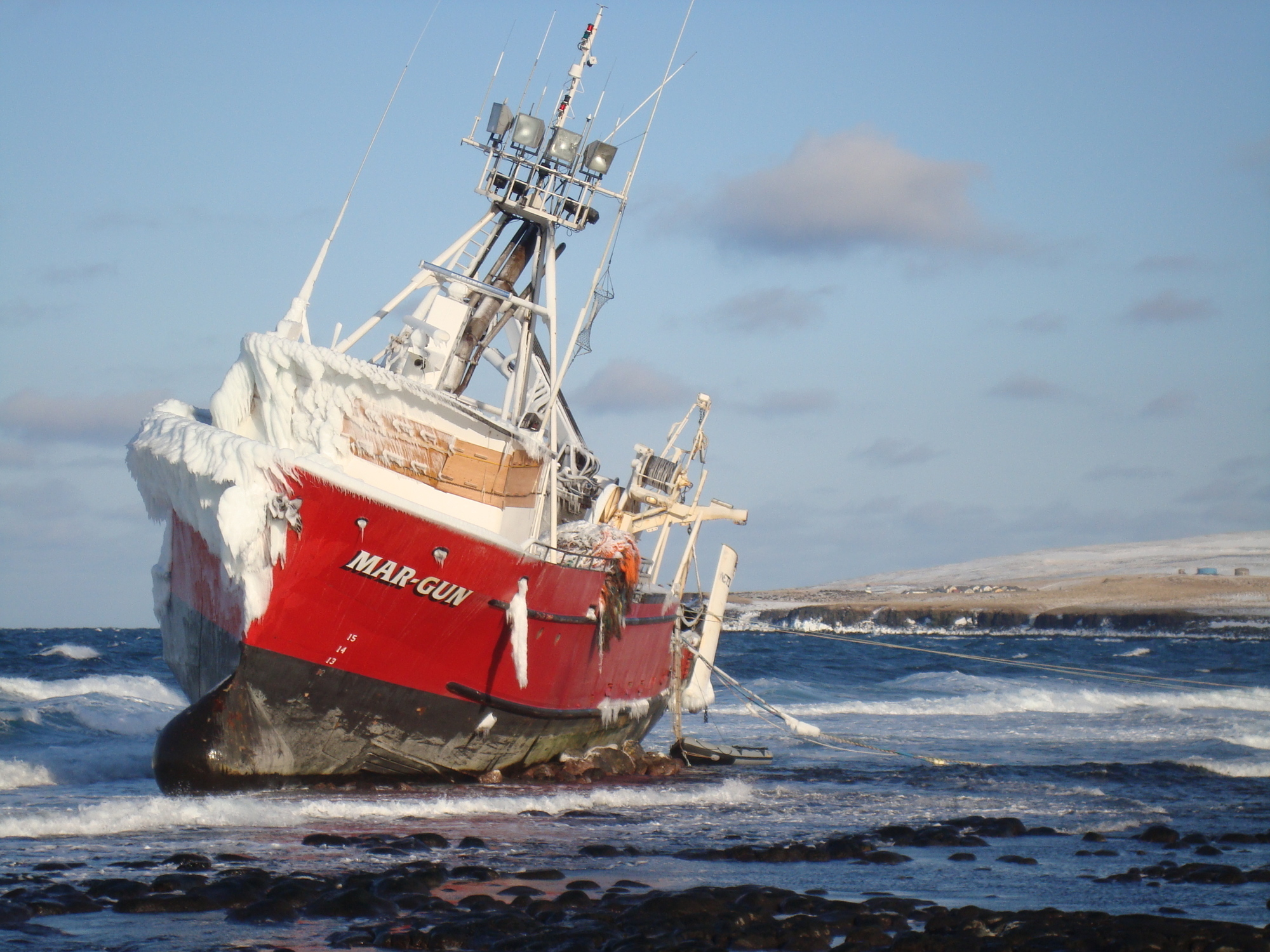 The fishing vessel Mar-Gun sits grounded with heavy ice accumulation on the north end of St. George Island in Alaska, April 11, 2009. A vessel's center of gravity can rapidly rise when freezing spray accumulates high above the main deck. U.S. Coast Guard photo.