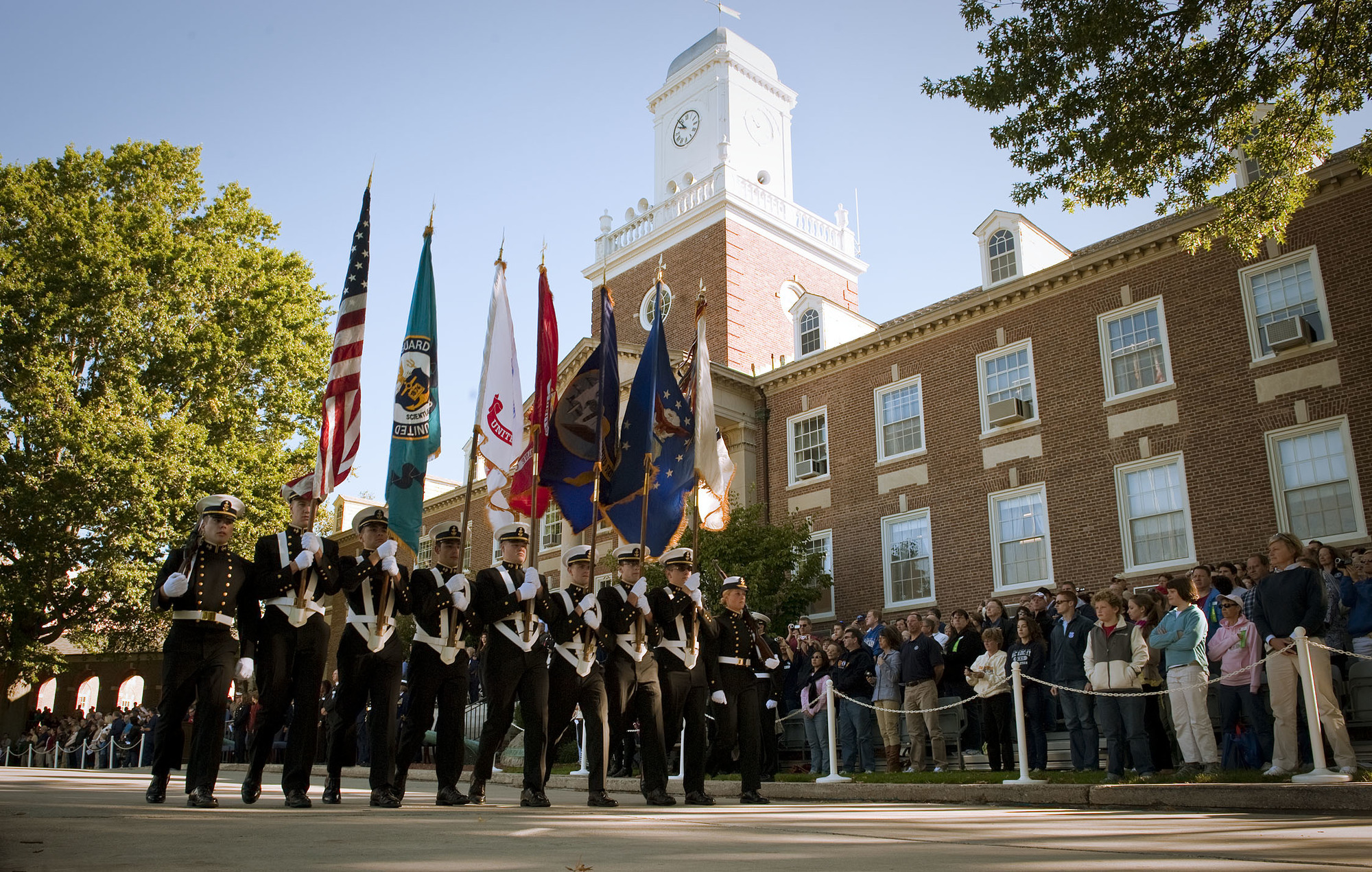 A color guard passes in front of Hamilton Hall at the Coast Guard Academy in New London, Conn.