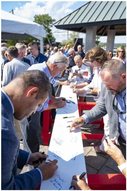 Coast Guard Museum chair members, government officials, and other honored guests sign the keel in New London, CT, Aug 19, 2022