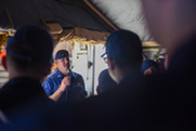 Coast Guard member speaking to workforce with a microphone