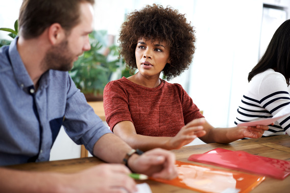 Two employees talking at a desk.