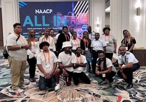 Coast Guard service members and participants at the NAACP convention pose for a picture.