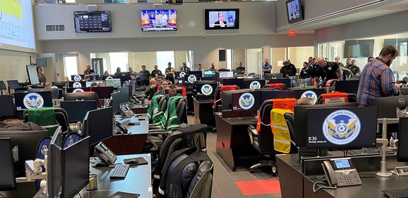 Image of exercise conducted in Fort Bend showing a room full of computers and individuals distributed throughout the room. 
