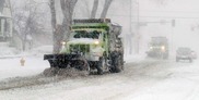 Snowplow cleaning streets during winter storms. 