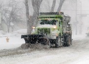 Image of a snowplow with snow falling and on the ground
