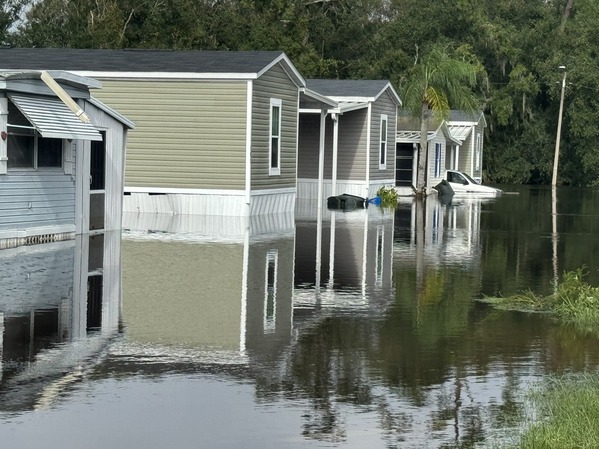 Standing water floods a row of mobile homes.