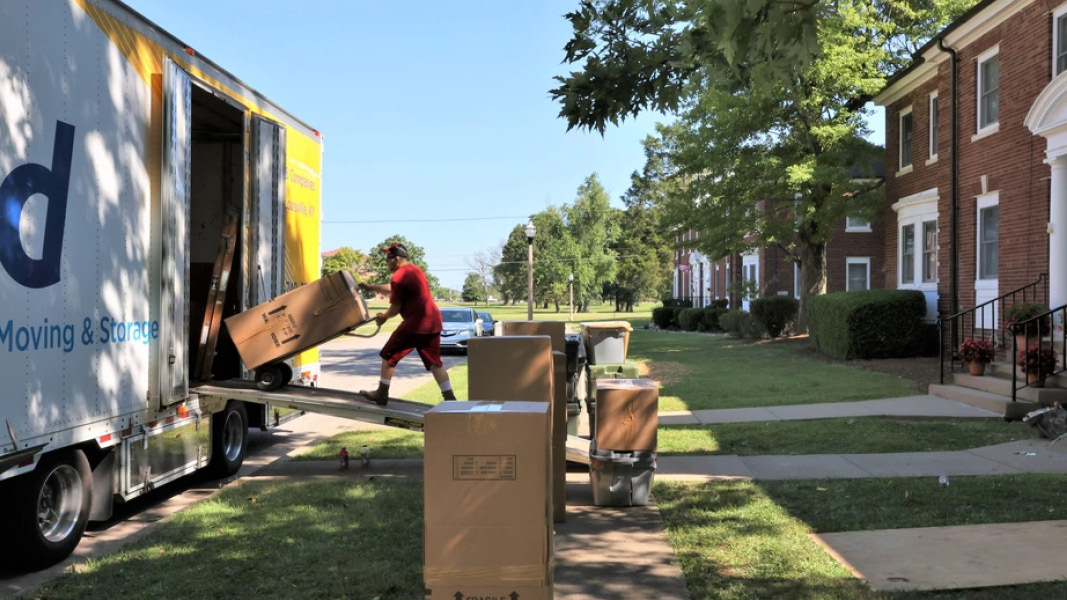 Man with moving cart at moving truck