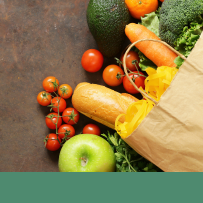 healthy groceries spilling out of a paper bag onto the counter