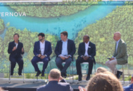 Speakers seated on stage during a GE Vernova event, with Assistant Secretary Katie Jereza holding a microphone and addressing the audience.