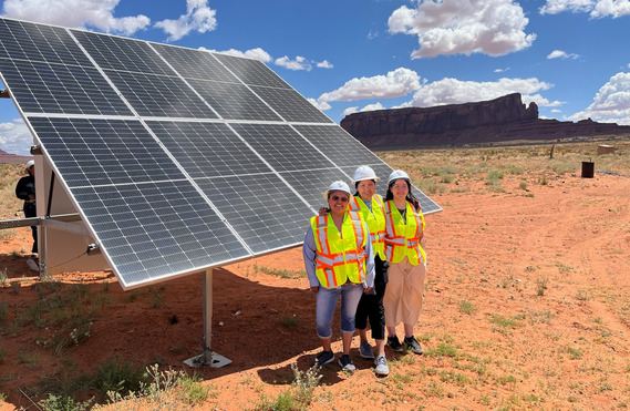 Tribal energy interns by solar panel on Navajo Nation.
