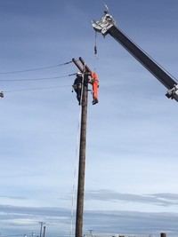 As part of an exercise, a Mission Support Alliance lineman climbed to the top of an electrical pole to rescue a 165 pound dummy. 