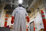 Commissioning Technician Quirino Quiroga learns to don and doff personal protective equipment as part of radiological worker training.