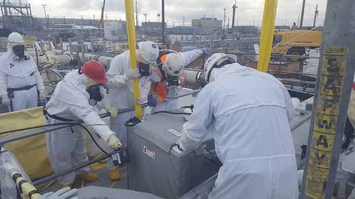 Workers install remotely operated, specialized equipment to retrieve waste from single-shell tank AX-103 at the Hanford Site.