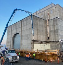 Workers with contractor CPCCo pour concrete for foundation to support cocooning structure for former K East Reactor building.