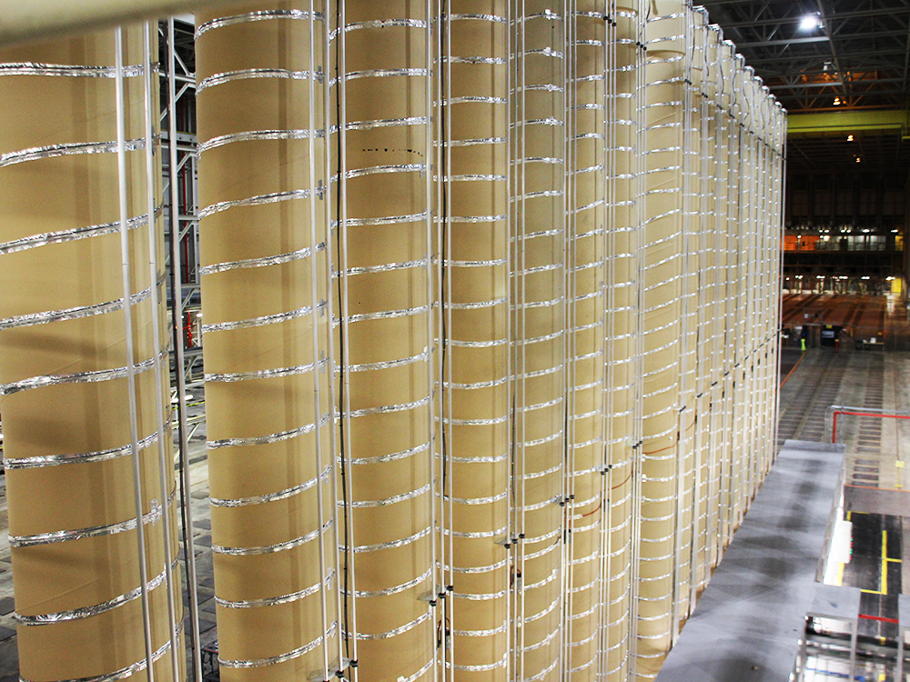 A row of tan cylinders wrapped in silver wire form an advanced enrichment cascade in Piketon, OH.