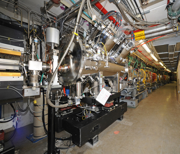 Photo of a particle accelerator structure  in a long, curving hallway