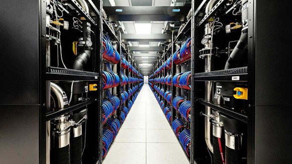 Photo of two open cabinets of the Aurora supercomputer so that you can see the red and blue coils of wire