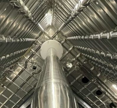 A large, shiny metal funnel that connects to a metal box made of panels