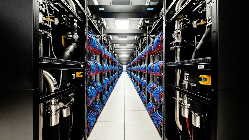 The Aurora supercomputer with its cabinet open. It has loops of red and blue wires connecting different parts of the computer. 