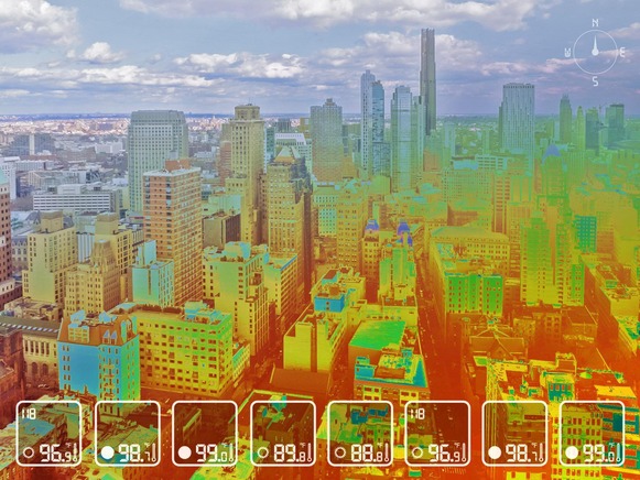 A photo of a city with a heat map overlaid on top, with red showing the warmest areas, which are in the high 90s.