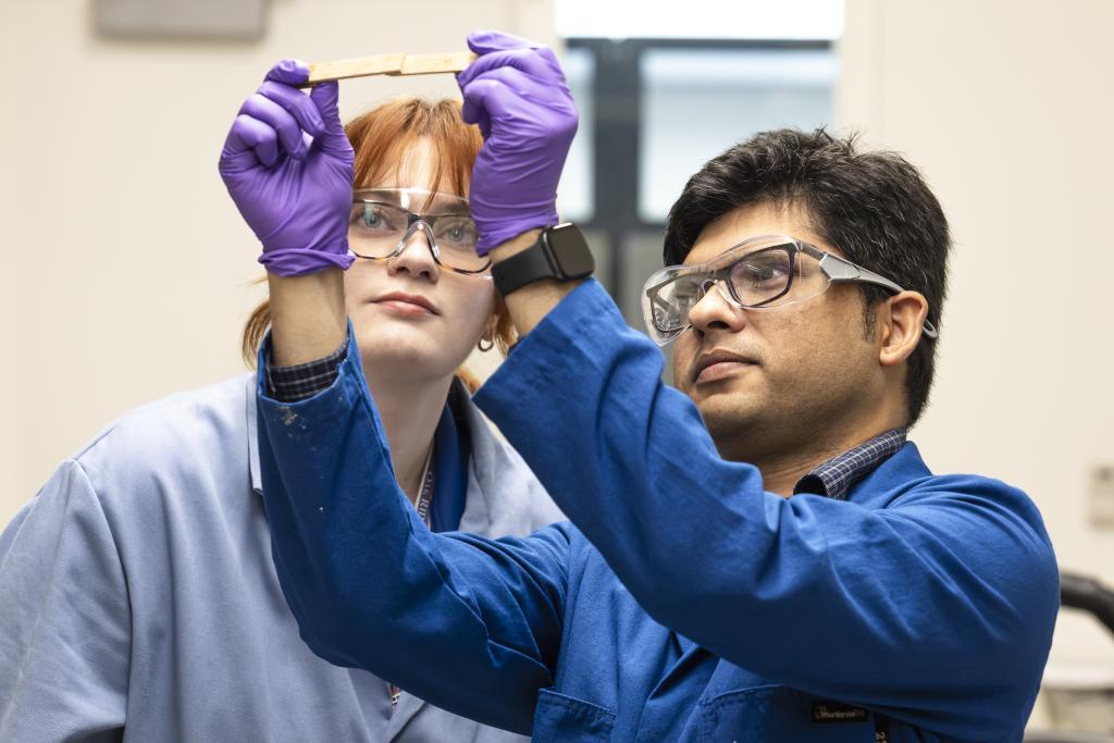 Scientists Mary Danielson and Anisur Rahman look at two pieces of material bound together with the reusable adhesive