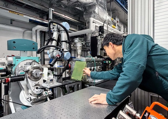 Diling Zhu places an X-ray sensitive plastic card in the interaction point at the X-ray Pump Probe instrument. 
