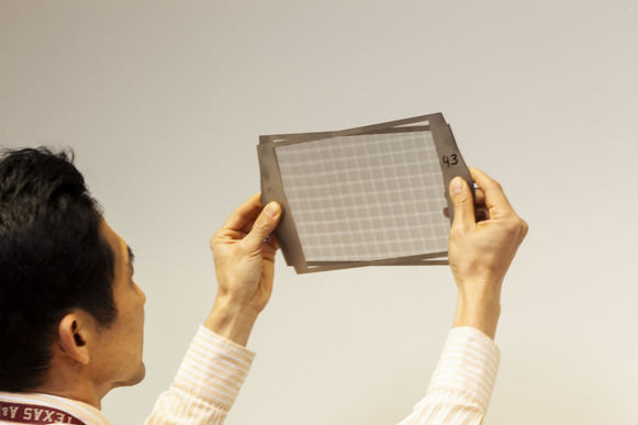 Seungjoon Lee holds prototype single tungsten sheets designed for the Variable-Angle Slant Hole Collimator.