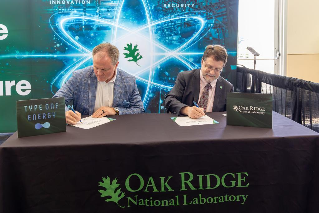 Senior Vice President of External Affairs for Type One Energy Matt Miles and ORNL Director Stephen Streiffer signing papers at a table.