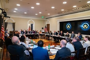 President Biden and staff seated around a rectangular table in the White House