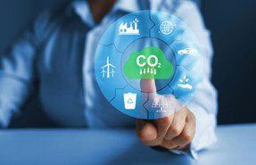 Person touching a CO2 graphic with images of renewable energy around it