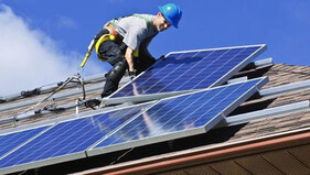 Worker installing solar panels on a roof