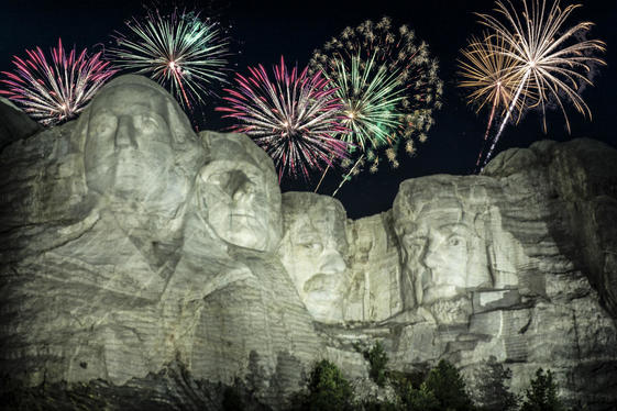 Sparkling fireworks explode in the night sky above the sculpture of the faces of four presidents at Mount Rushmore.