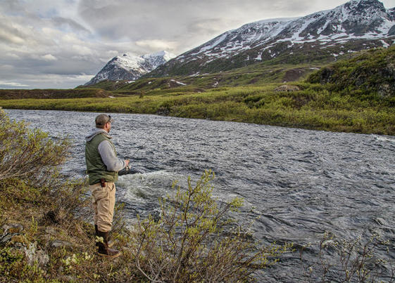 A man fishing alongside a river in Alaska. Photo by Bob Wick, BLM.
