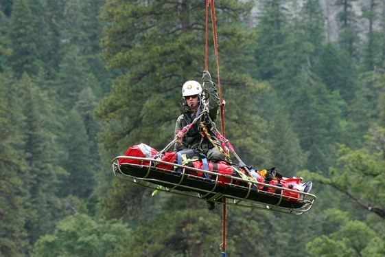 Leslie Reynolds hangs from a helicopter after successfully rescuing a visitor.