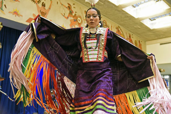 A Native American woman in traditional clothes dances at a Native American heritage event. Photo by Bureau of Indian Affairs.